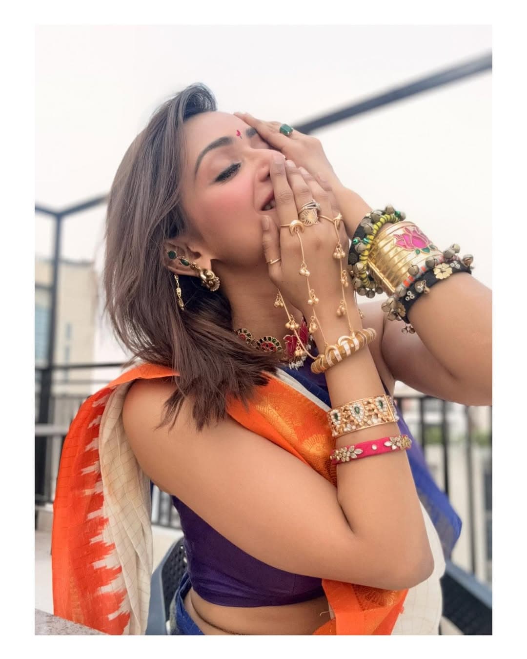 শাড়ির সঙ্গে গাঢ় ভায়োলেট হাই নেক স্লিভলেস ব্লাউজ বেছে নিয়েছেন তিনি।